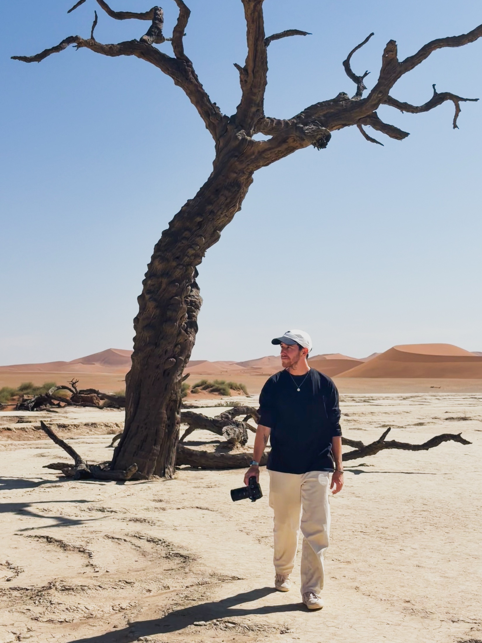 Fabian Götz mit Kamera in einer Wüstenlandschaft.