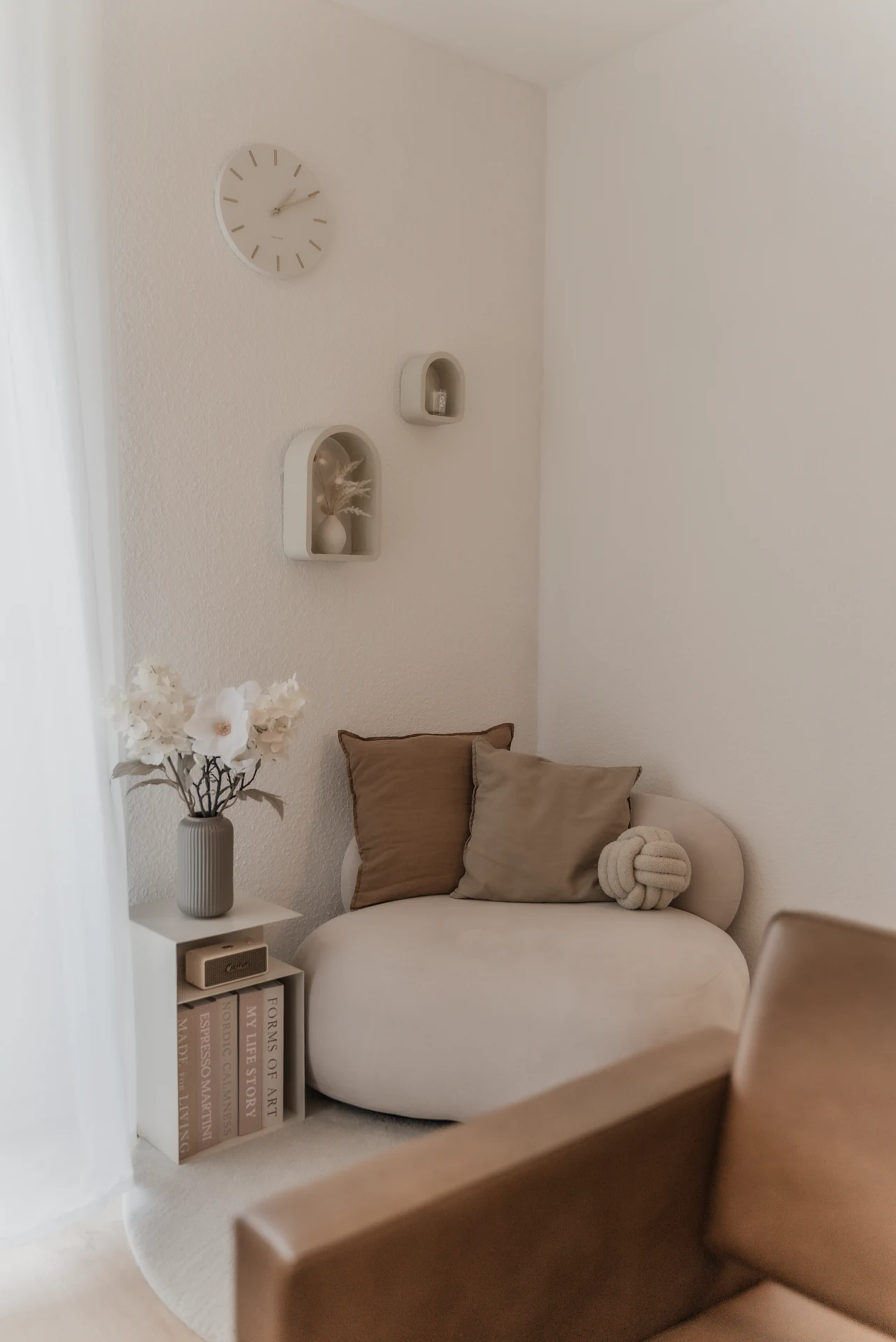 Detail der Sitzecke mit Blumen, Wandnischen und Textilien.